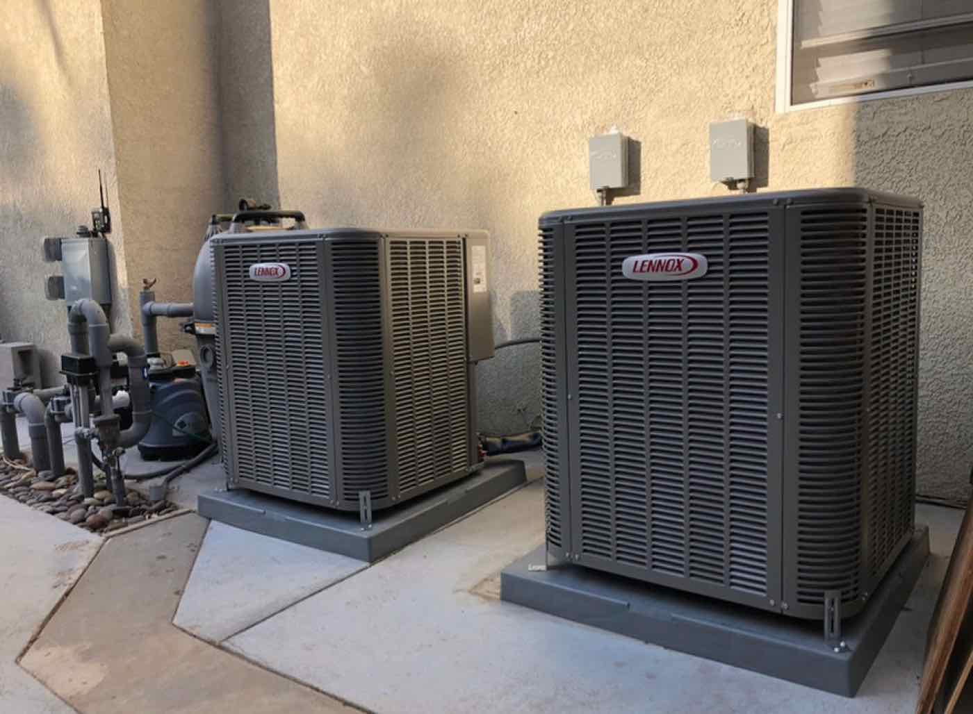 Two new outdoor AC condensers on a pad.