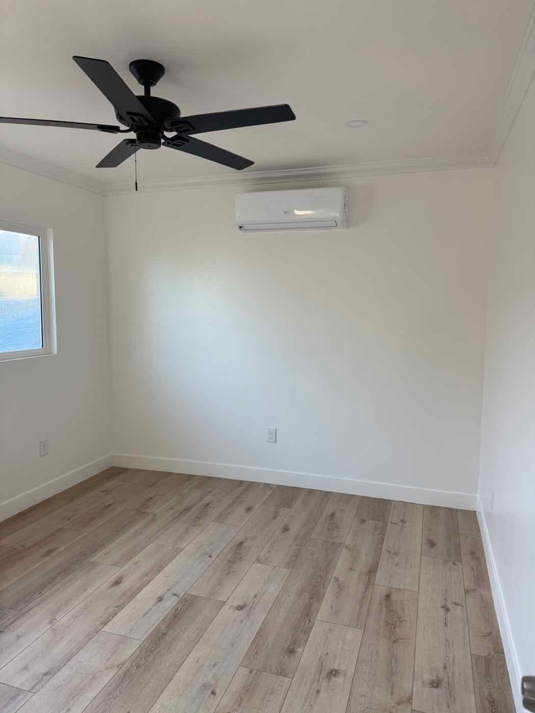 A wall-mounted mini-split in a bright, empty room.