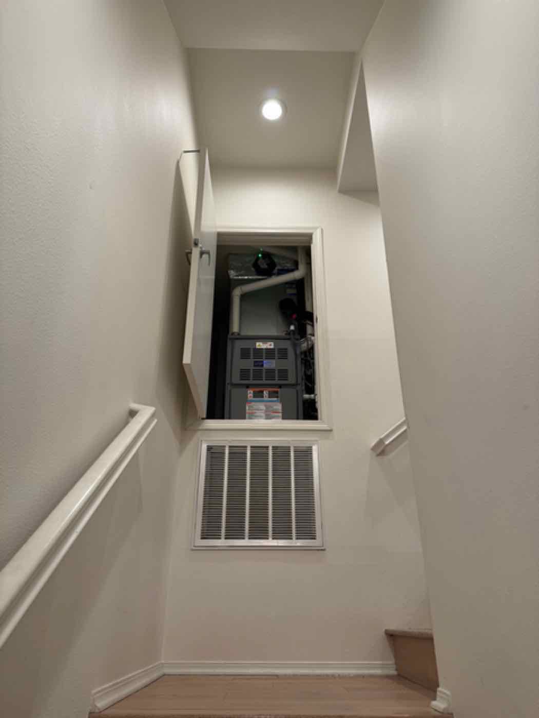 A return air vent and air handler in a hallway closet.